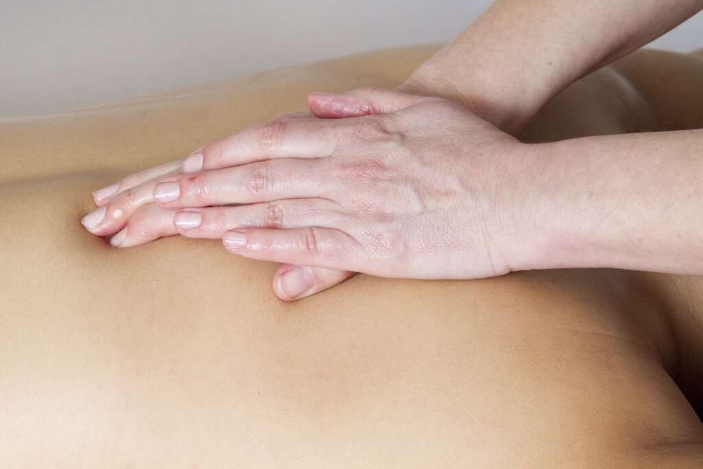 Massage auf dem oberen Rücken mit beiden Händen